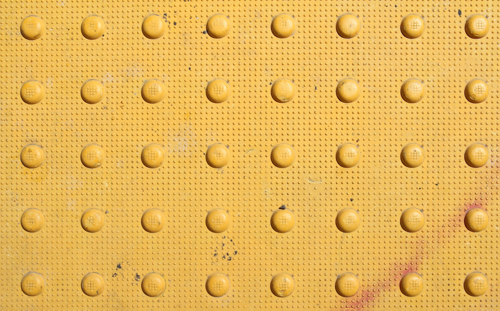 a close up of a yellow wall with lots of dots